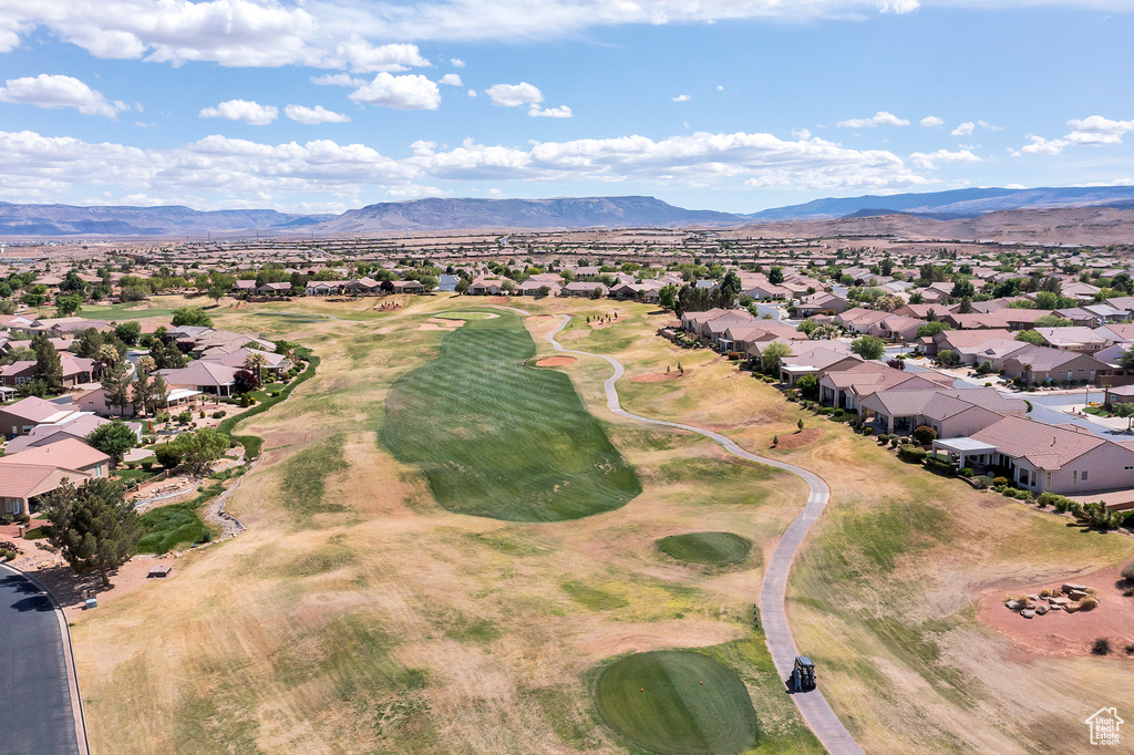 View of property location featuring nearby suburban area, a mountain backdrop, and a golf course