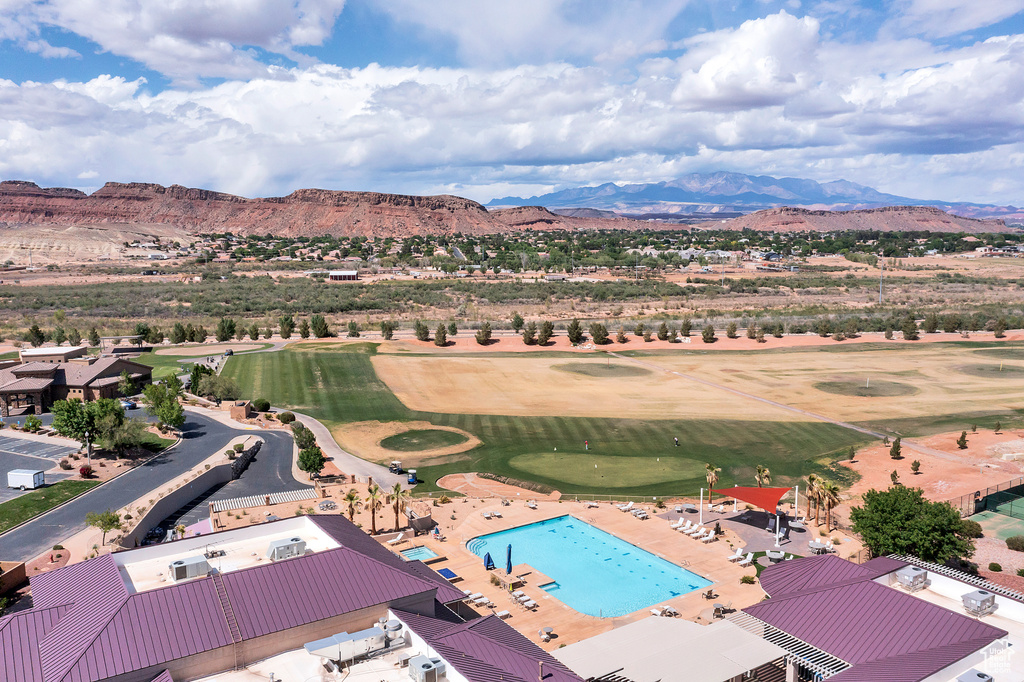 Drone / aerial view of a mountainous background, a pool, and a local golf course
