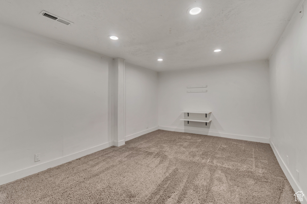 Finished below grade area with carpet floors, baseboards, recessed lighting, and visible vents