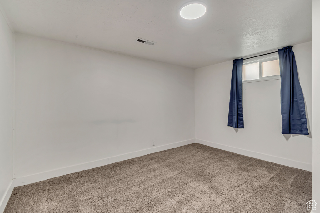 Carpeted spare room with baseboards and visible vents