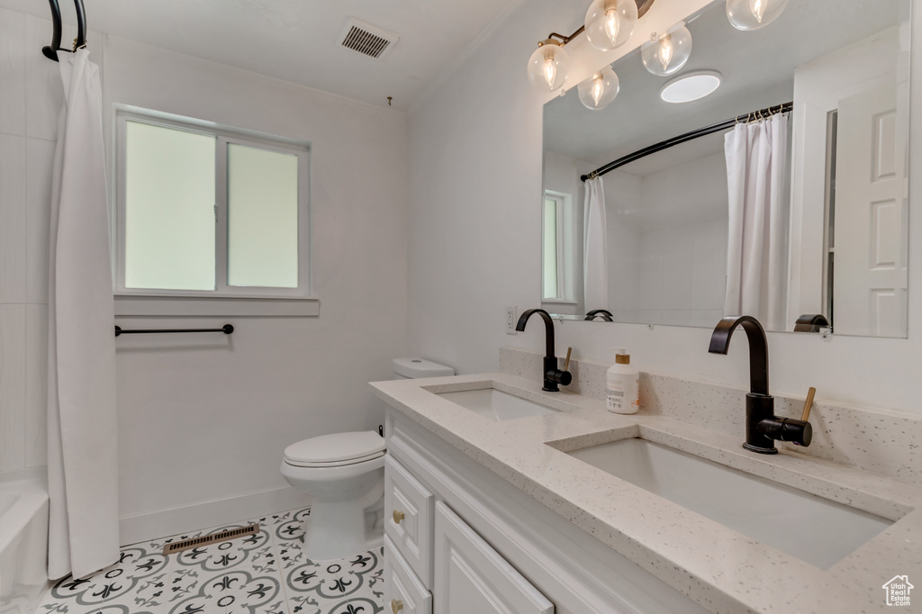 Full bathroom with toilet, visible vents, a sink, and tile patterned flooring