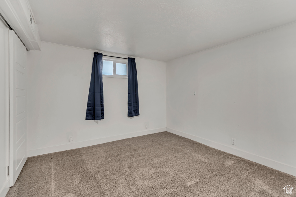 Carpeted empty room featuring baseboards