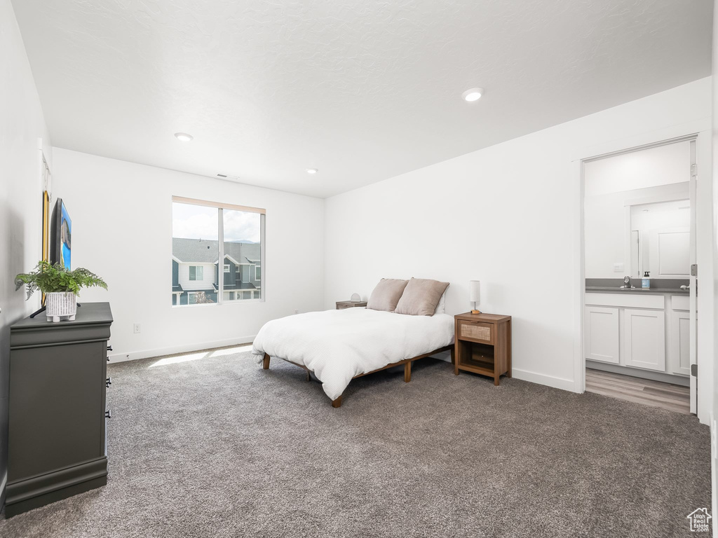Bedroom with carpet floors, baseboards, connected bathroom, recessed lighting, and a sink