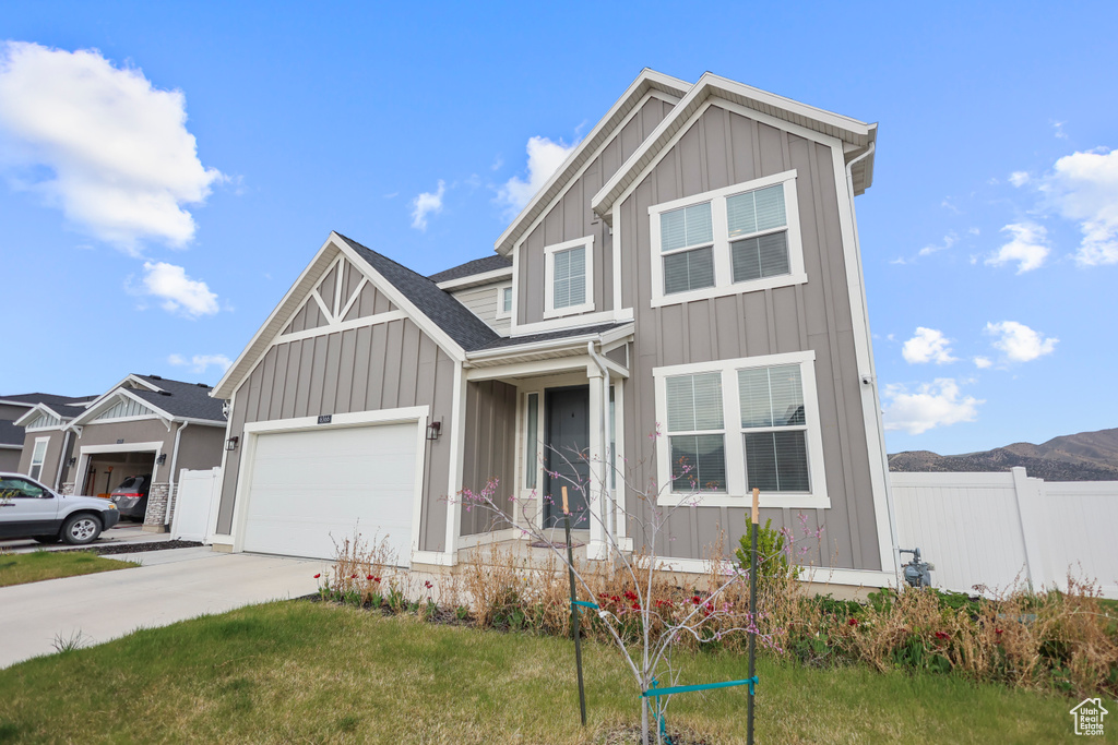 View of front of home with board and batten siding, driveway, and a garage