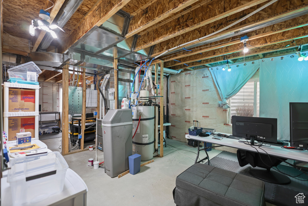 Unfinished below grade area with secured water heater and an office area