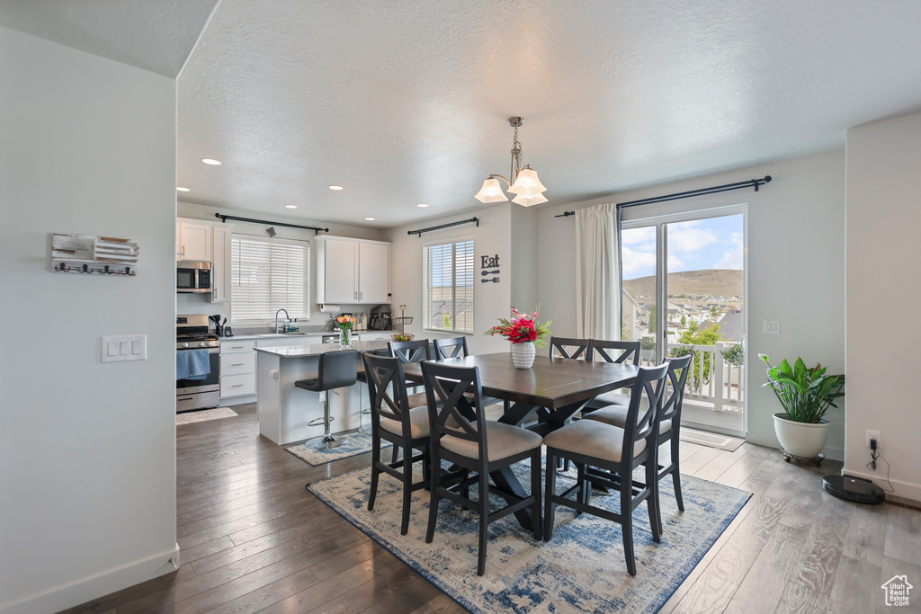 Dining space with hardwood / wood-style floors, baseboards, recessed lighting, and a textured ceiling
