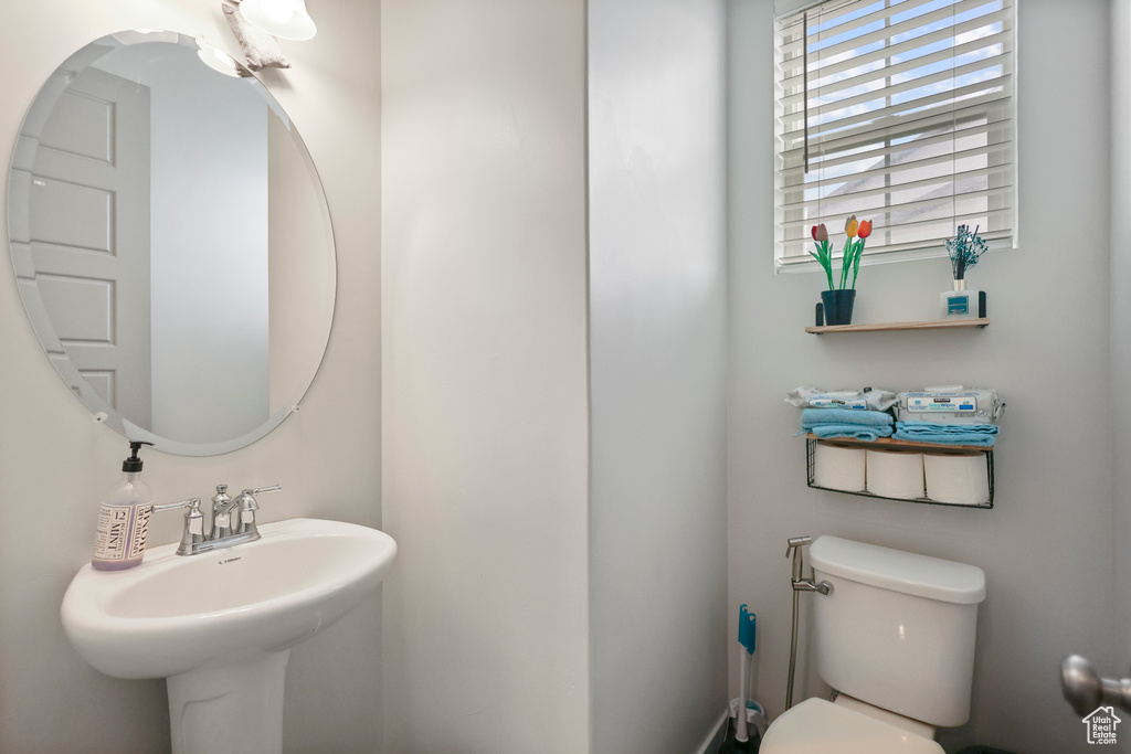 Half bath featuring toilet and a sink