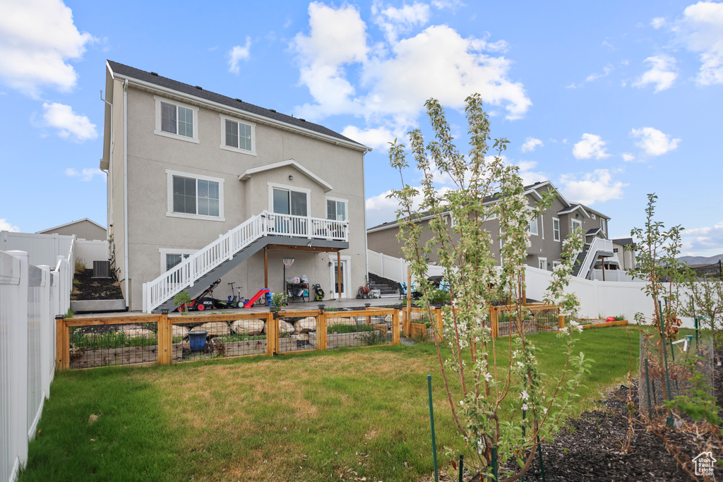 Back of house with stucco siding and stairs