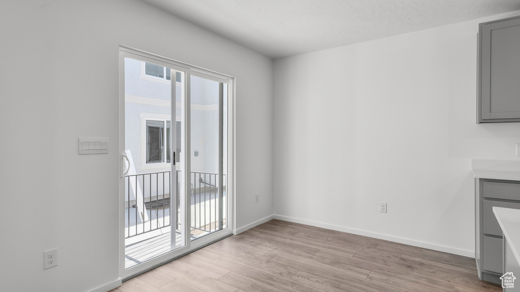 Unfurnished dining area with light wood-style floors and baseboards