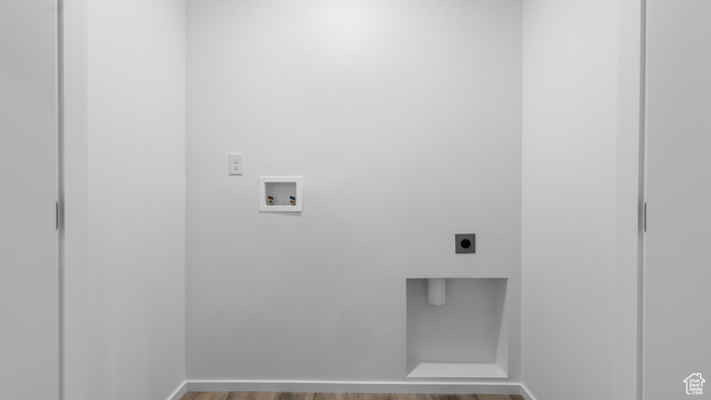 Laundry area with electric dryer hookup, washer hookup, and wood finished floors
