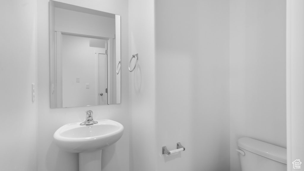 Half bath featuring toilet and a sink