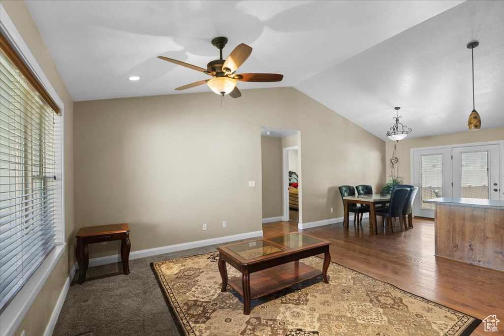 Living room featuring a ceiling fan, vaulted ceiling, recessed lighting, baseboards, and wood finished floors