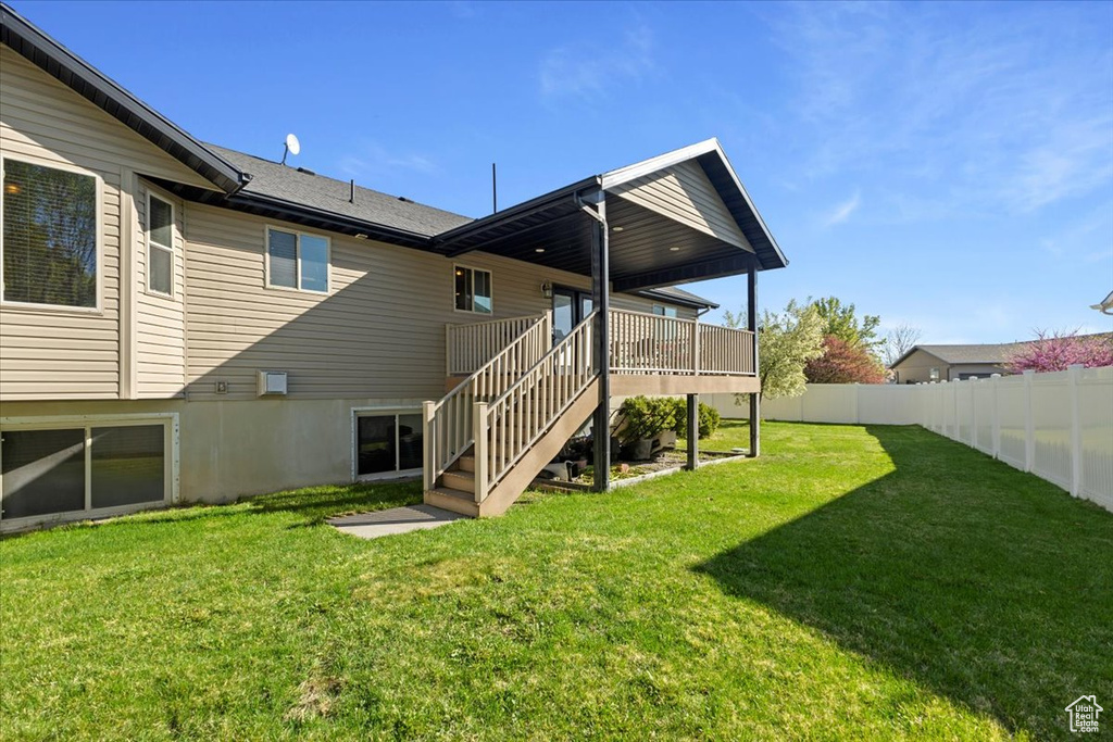Back of house with a yard, stairs, fence, and a deck