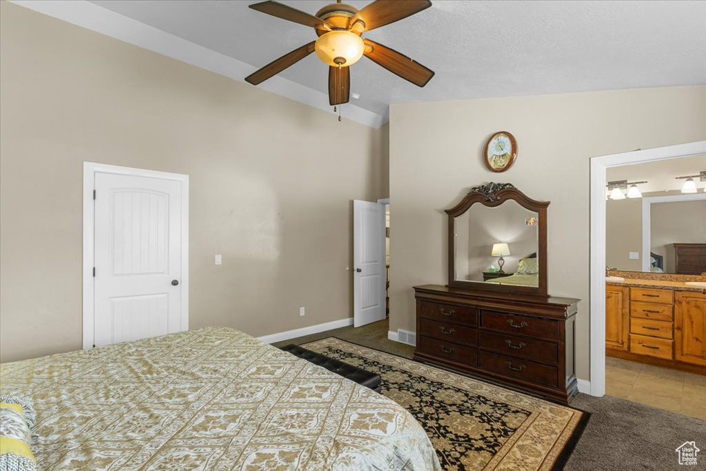 Bedroom featuring baseboards, ensuite bath, a ceiling fan, and light colored carpet