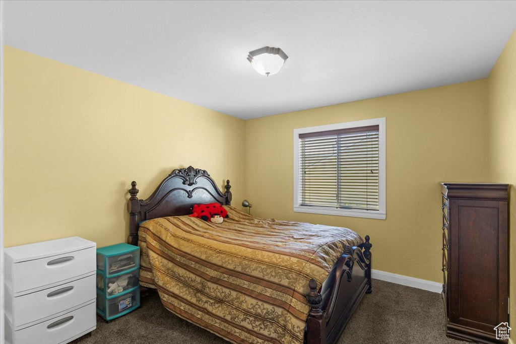 Bedroom featuring baseboards and dark colored carpet