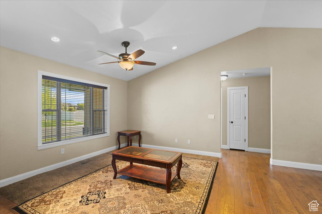 Living area with a ceiling fan, vaulted ceiling, recessed lighting, baseboards, and wood finished floors