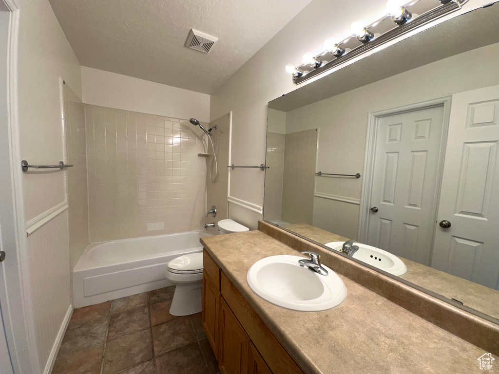 Bathroom featuring toilet, baseboards, vanity, and shower / tub combination