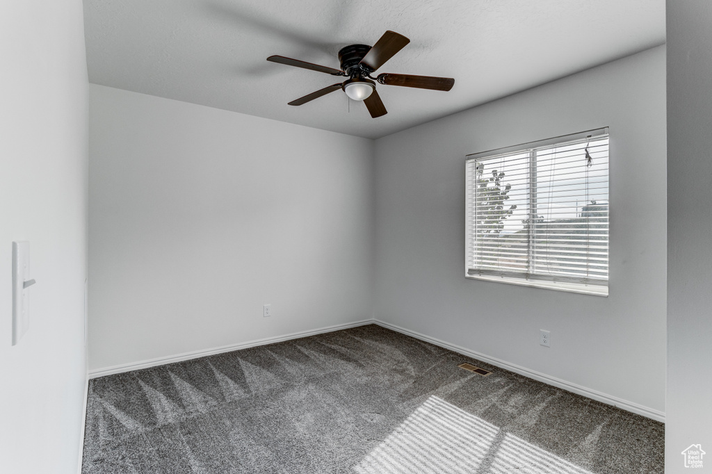 Spare room with carpet flooring, a ceiling fan, and baseboards