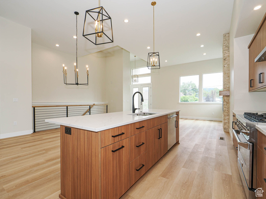 Kitchen featuring stainless steel appliances, a chandelier, a sink, light wood-style floors, and recessed lighting