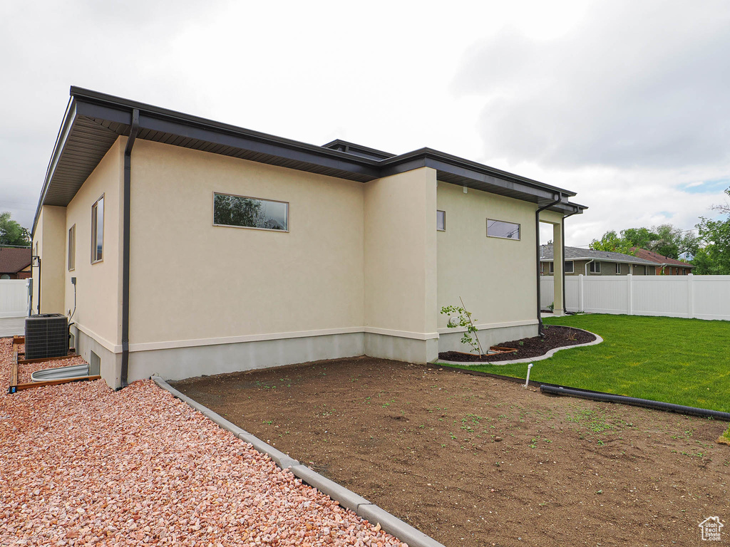 View of home\'s exterior with cooling unit and stucco siding