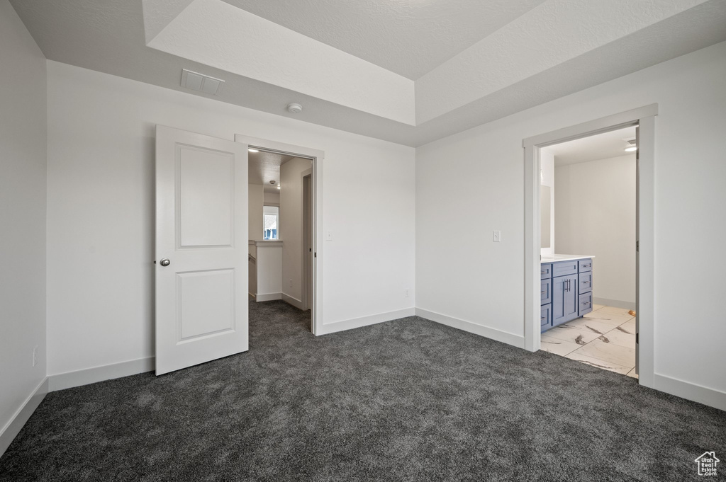 Unfurnished bedroom featuring baseboards, carpet flooring, and connected bathroom