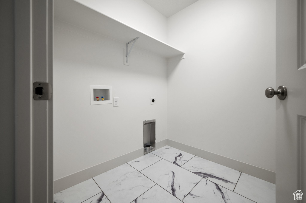 Laundry area featuring hookup for a washing machine, light marble finish flooring, electric dryer hookup, and baseboards