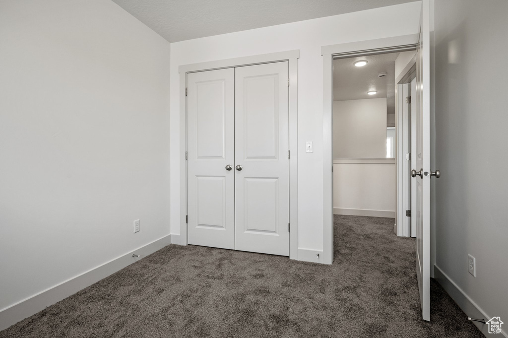 Unfurnished bedroom featuring carpet flooring, a closet, and baseboards