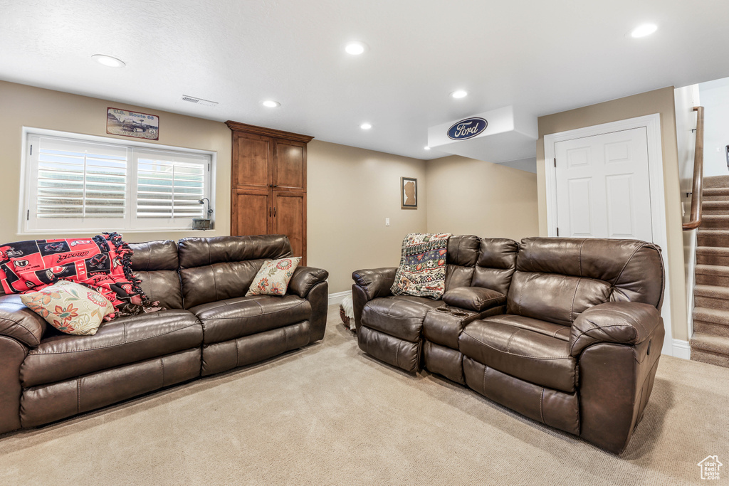 Carpeted living area featuring baseboards, stairway, visible vents, and recessed lighting
