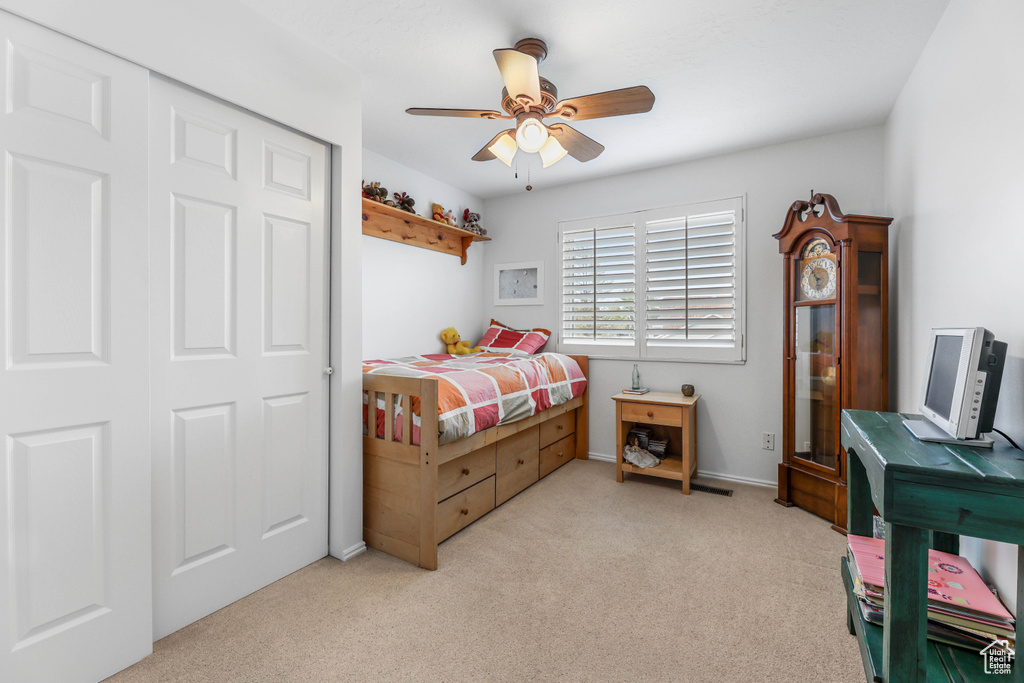 Bedroom with a ceiling fan, light carpet, and baseboards