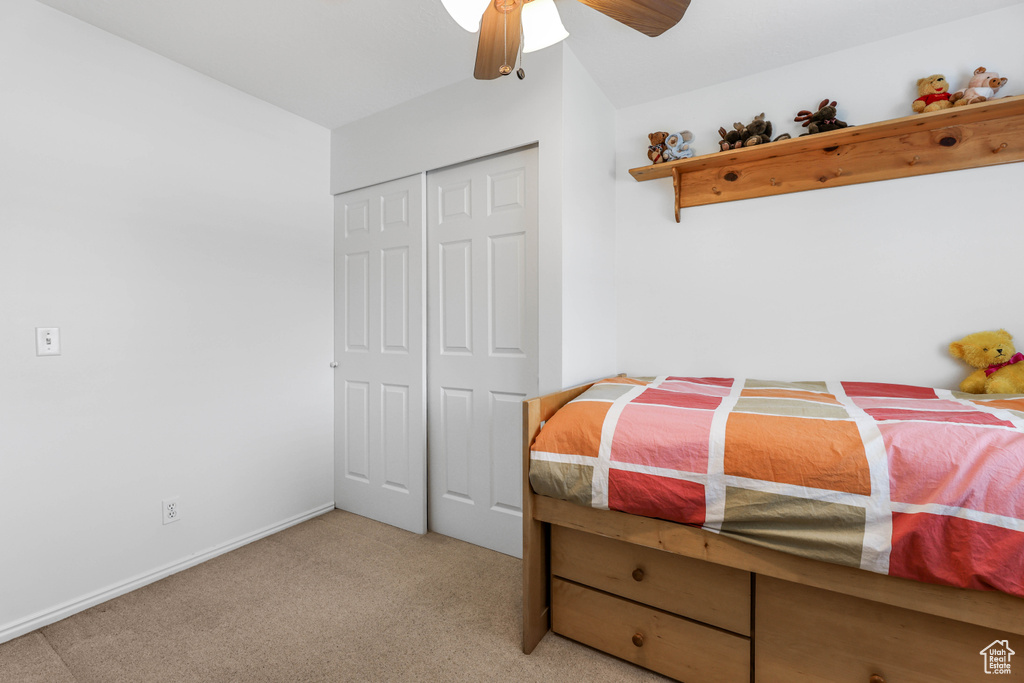 Bedroom featuring ceiling fan, carpet flooring, a closet, and baseboards