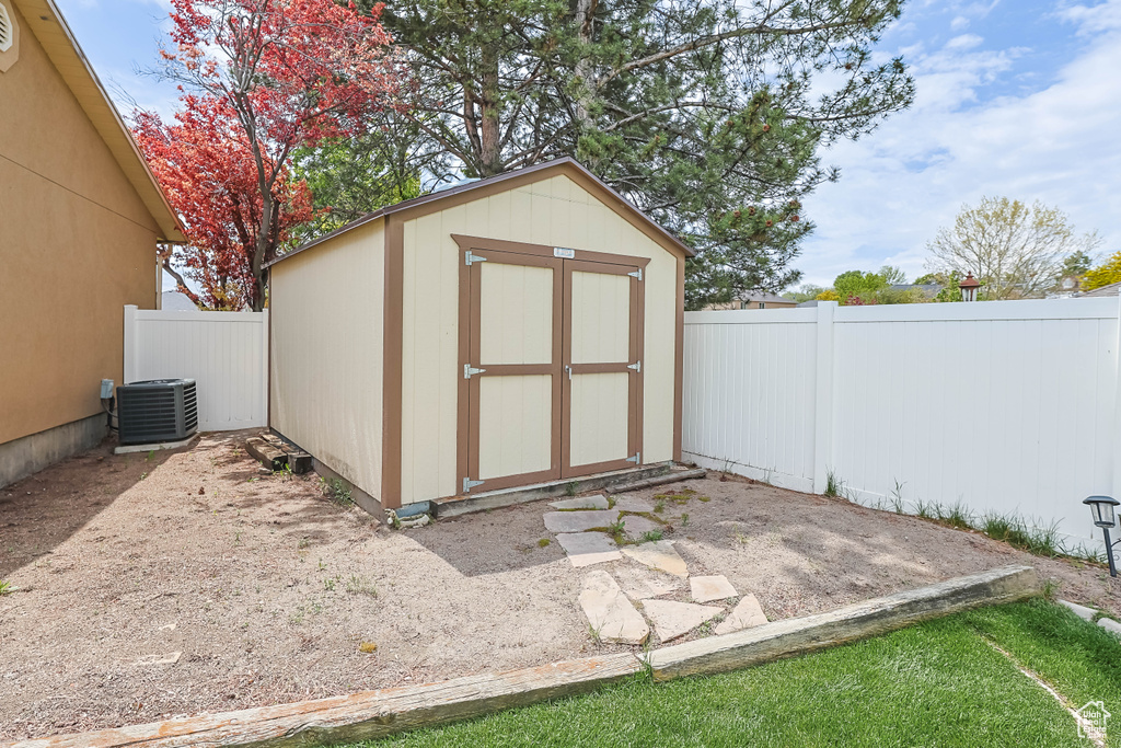 View of shed with a fenced backyard and central AC