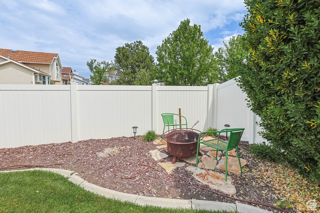 View of yard with a fire pit and fence