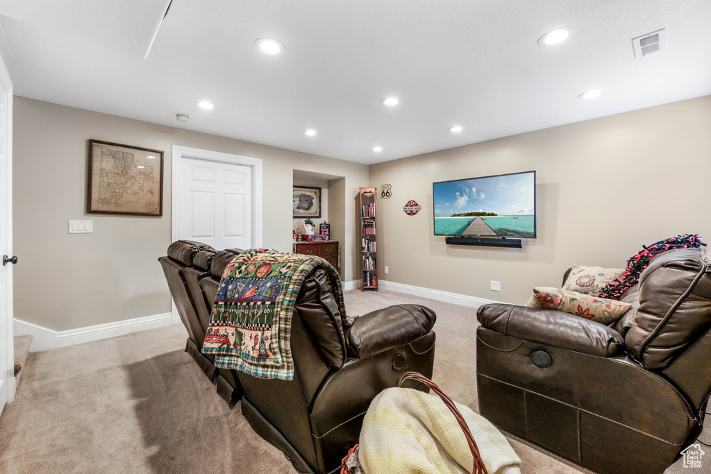 Carpeted living area featuring baseboards, visible vents, and recessed lighting