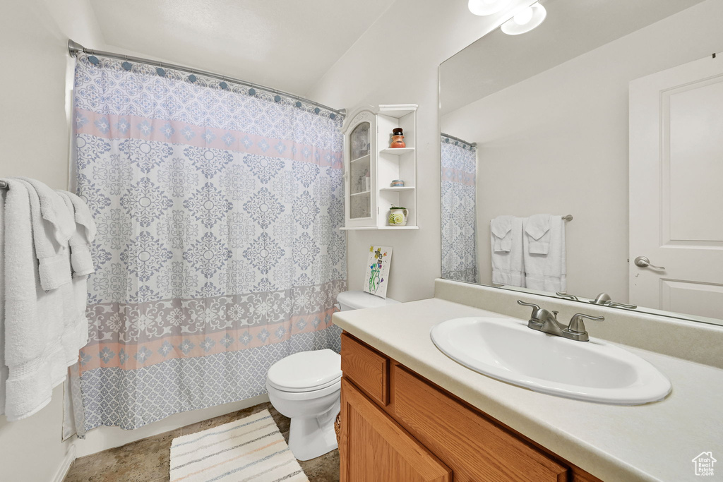 Full bathroom featuring toilet, vanity, and curtained shower