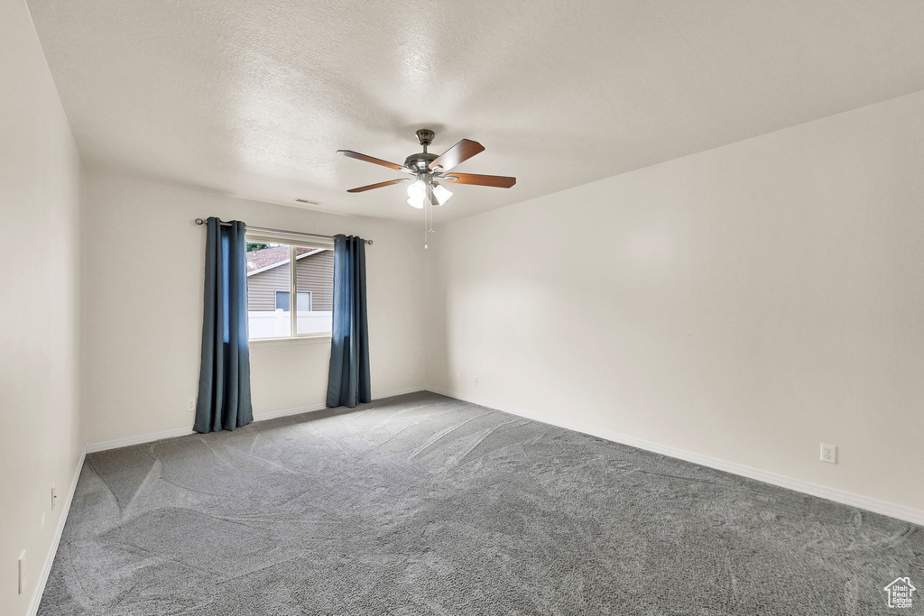 Unfurnished room with carpet, ceiling fan, a textured ceiling, and baseboards