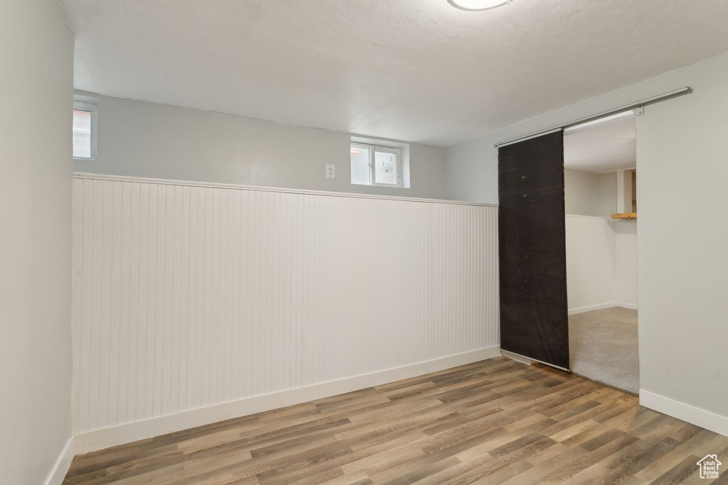Below grade area featuring a wainscoted wall and wood finished floors