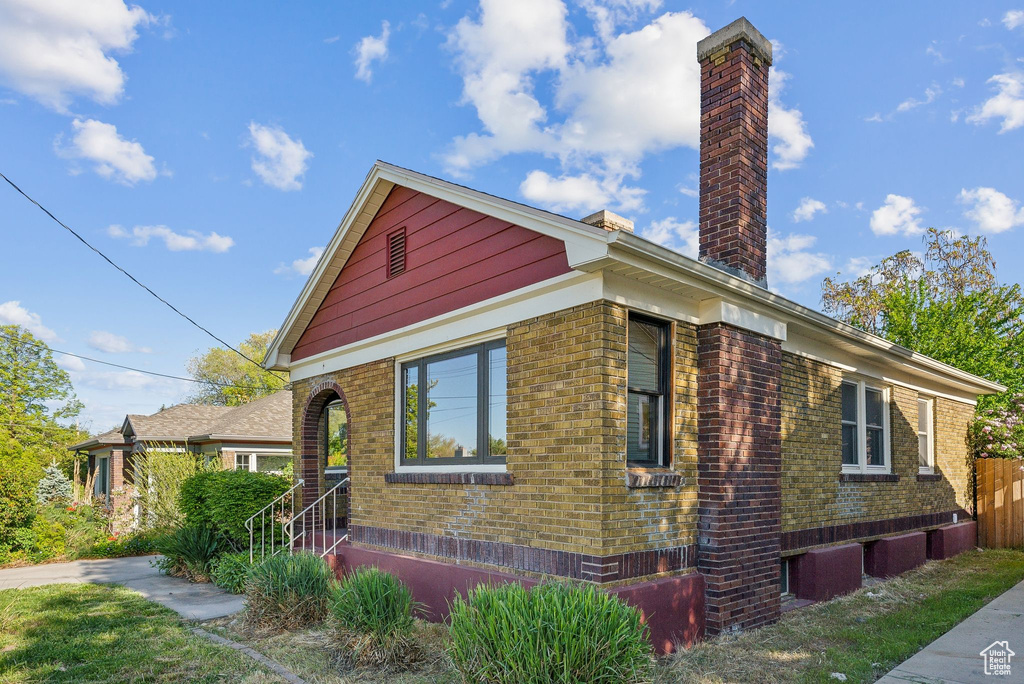 View of front of house with brick siding and a chimney