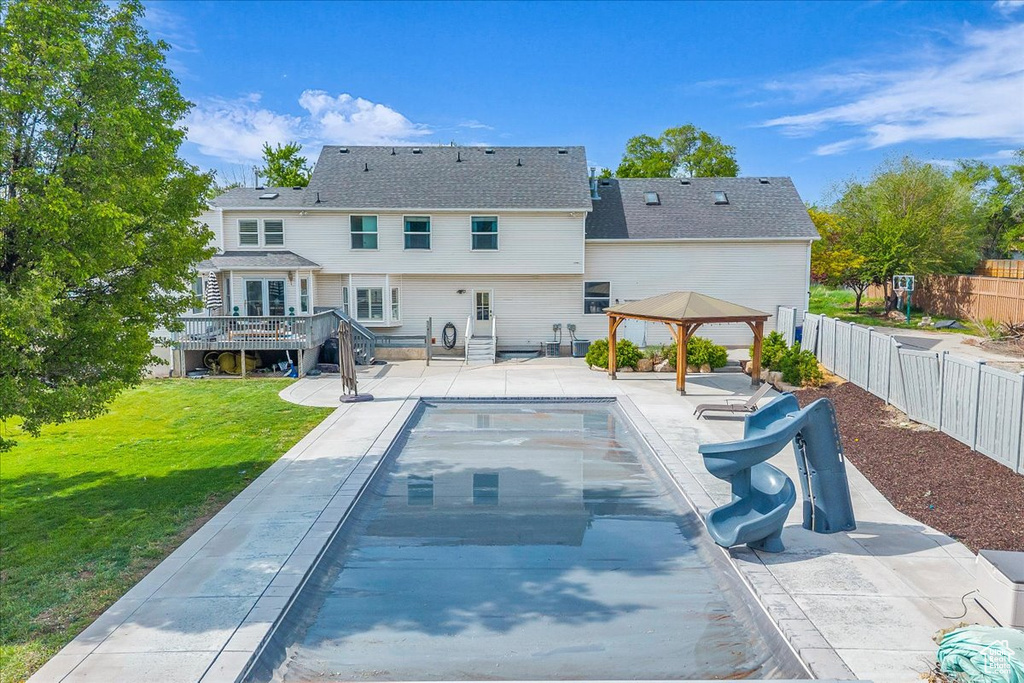 Rear view of property featuring a wooden deck, a gazebo, and a patio area