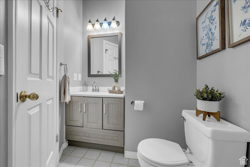 Bathroom featuring toilet, tile patterned floors, vanity, and baseboards