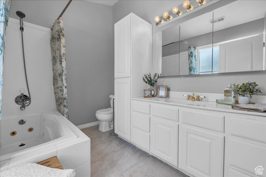 Bathroom featuring toilet, vanity, and a combined bath / shower with jetted tub