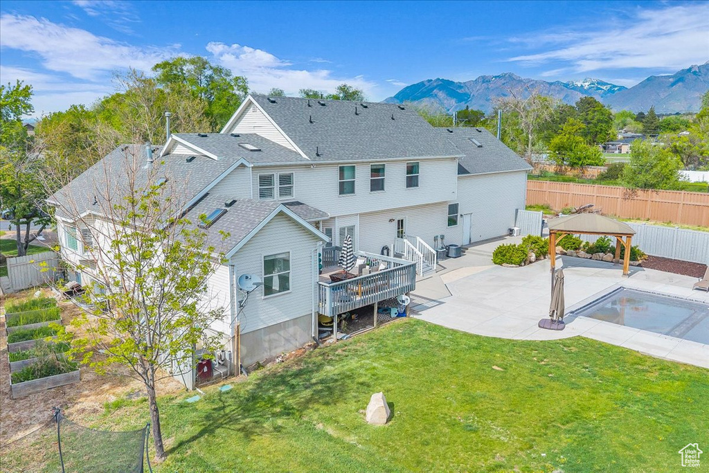 Back of house with a gazebo, a patio area, a mountain view, and roof with shingles