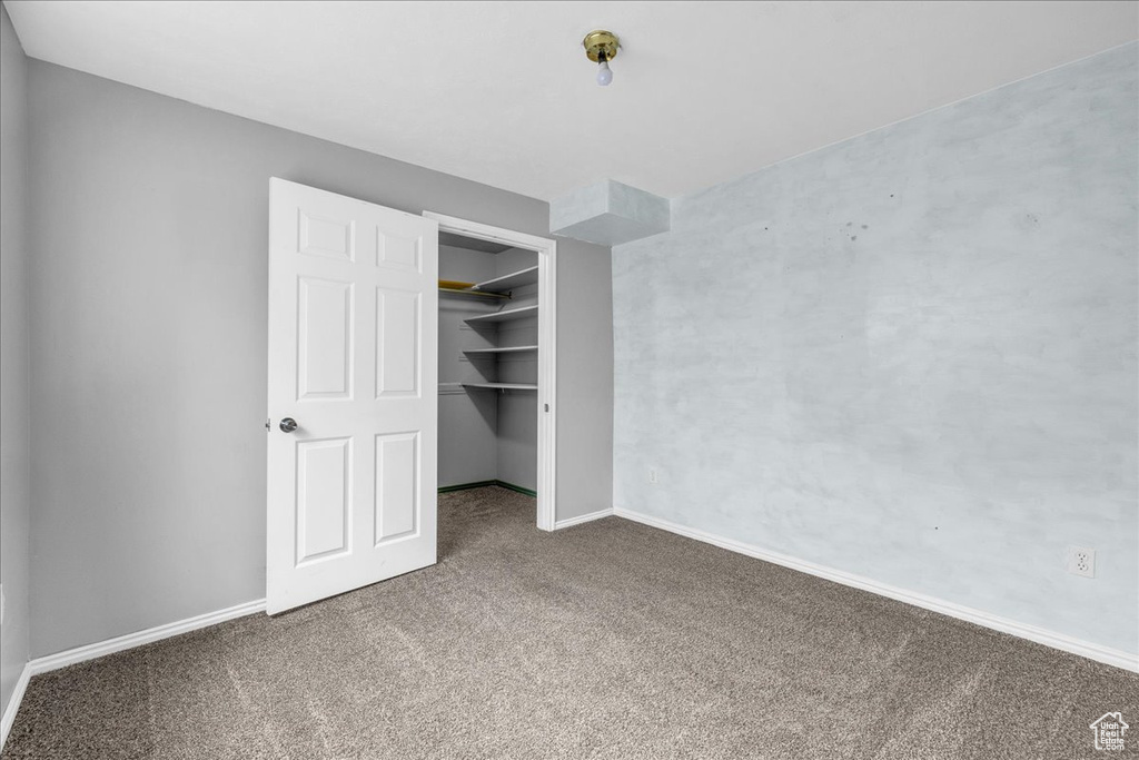 Unfurnished bedroom featuring carpet flooring, baseboards, and a closet