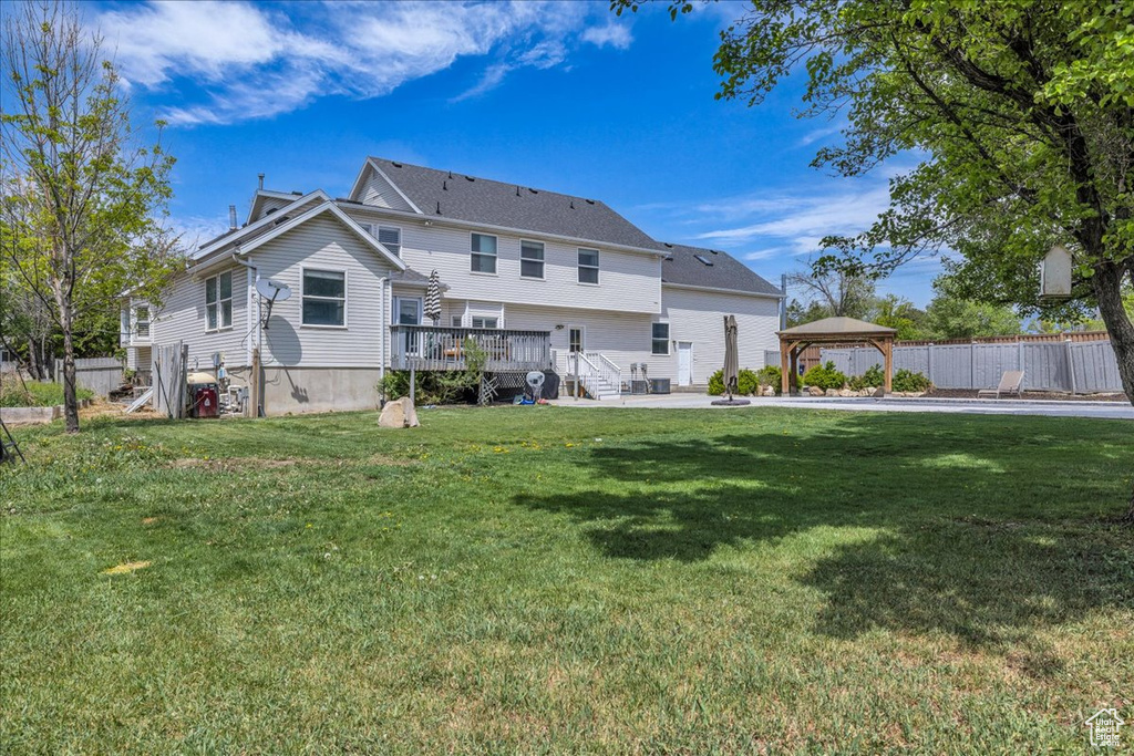 Rear view of property with a gazebo and a wooden deck