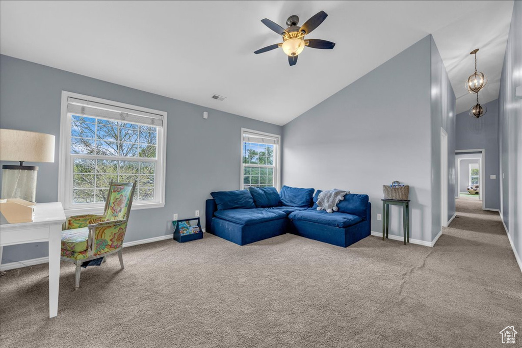 Carpeted living area featuring a ceiling fan, baseboards, and high vaulted ceiling