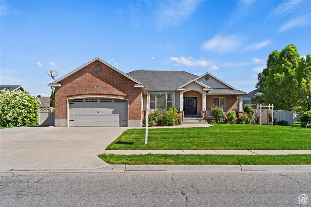 View of front facade featuring brick siding, an attached garage, and concrete driveway