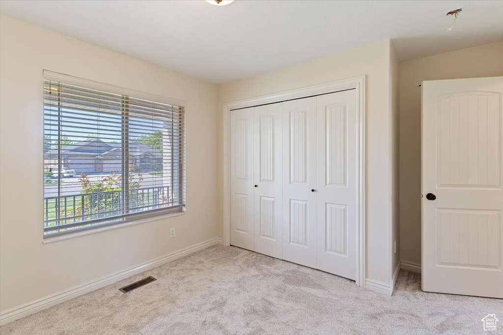Unfurnished bedroom with carpet flooring, baseboards, and a closet