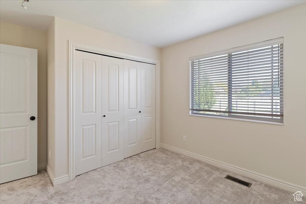 Unfurnished bedroom featuring carpet floors, a closet, and baseboards
