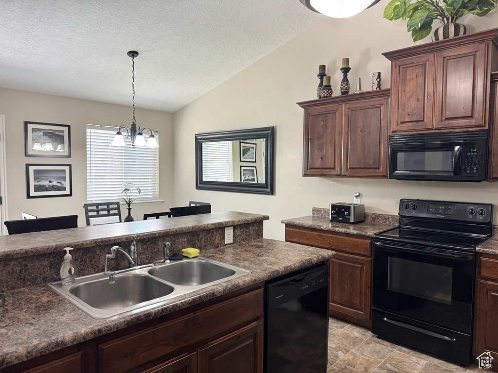 Kitchen featuring black appliances, dark countertops, a sink, and vaulted ceiling