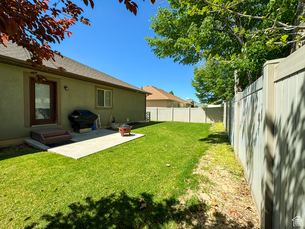 View of yard featuring a fenced backyard and a patio