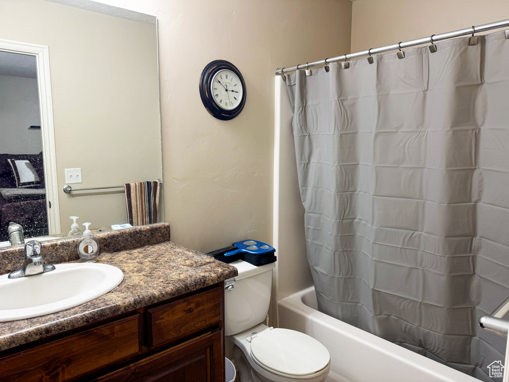 Full bath with toilet, shower / tub combo with curtain, and vanity